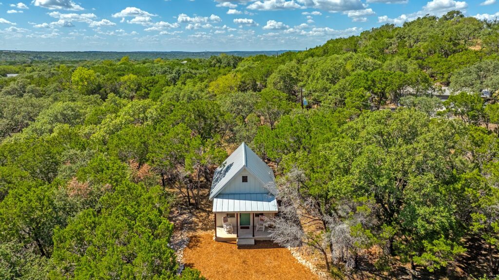 Aerial view of the cottage tucked among Hill Country oaks at The Cottage at The Gathering Oak in Wimberley, Texas