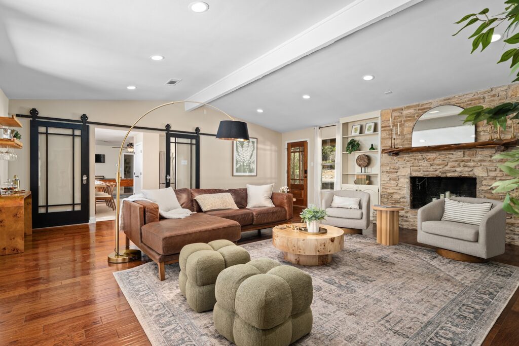 Open living area with barn doors and fireplace at The Gathering Oak in Wimberley, Texas